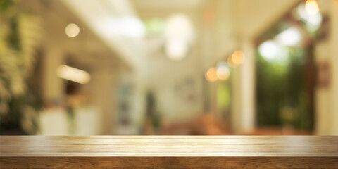 Empty wooden table top with blurred coffee shop or restaurant interior background. Panoramic...