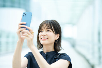 Fototapeta na wymiar スマートフォンの画面を見る若い女性