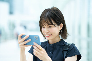 スマートフォンの画面を見る若い女性