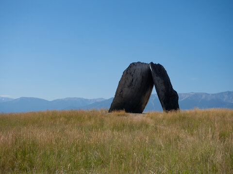 Inverted Portal Sculpture at Tippet Rise Art Center in Montana with Grassy Field in Foreground and Beartooth Mountain Range in Distance