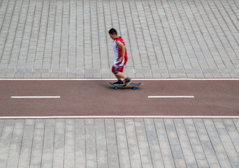 a young man play skateboarding in action on street, motion blurred people