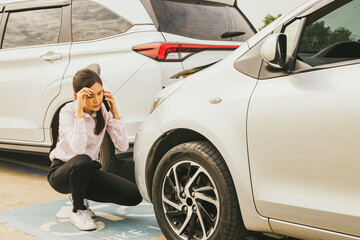 Asian woman sits stressed and worried as her reckless driver hits the back of her car and damages the front. Sit and use your smartphone to call your insurance company for help with repairs. - obrazy, fototapety, plakaty