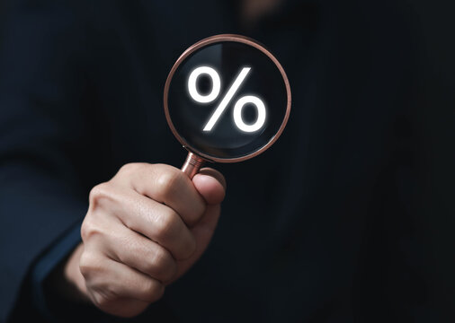magnifying glass showing the percentage symbol icon. Investing profits increases or decreases stocks.