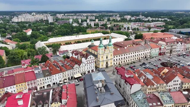 Historic church and square lined by historic traditional homes. Hradec Kralove, Czechia. Drone fly to