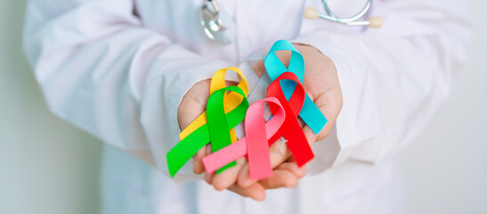 World cancer day, February 4. Doctor hold colorful ribbons, blue, yellow, red, green, white, pink...