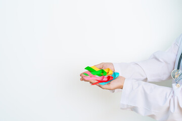 World cancer day, February 4. Doctor hold colorful ribbons, blue, yellow, red, green, white, pink and grey for supporting people living and illness. Health, Medical, awareness and Insurance concept