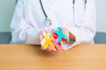 World cancer day, February 4. Doctor hold colorful ribbons, blue, yellow, red, green, white, pink...