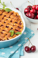 Piece of delicious homemade cherry pie with Flaky Crust sprinkled with sugar on the white marble background. American traditional cherry tart.
