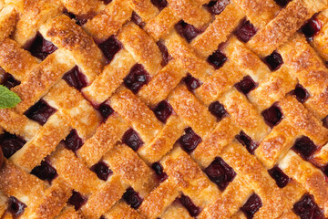 Delicious homemade cherry pie with Flaky Crust as a textured background. American traditional pastry. Flat lay. Fresh summer berry tart dessert sprinkled with sugar © alexanderon