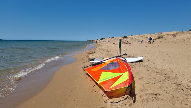 corfu keryra beach issos in summer sunny day ubrellas water sports windsurfing and clear colors for background greece