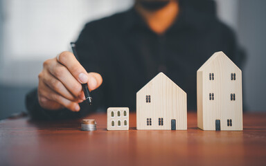 Agent holding a model house in hands, symbolizing real estate concepts for buying, selling, and securing homes and properties