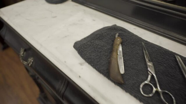 Scissors And Shaving Tools In The Towel, With A Neck Duster Brush On Top Of The Barber Shop Table.