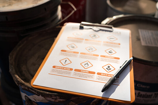 A balloint pen is placed on hazardouse chemical checking icon sysmbol, that using for correct the risk of chemical at storage warehouse area. Industrial safety working scene concept, selective focus.