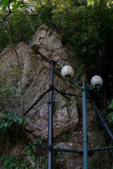 Broken Lamp posts leaning on a rock on the side of a mountain