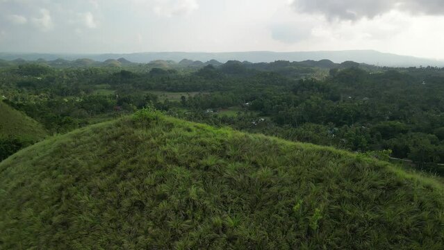Philippines, Bohol, Chocolate Hills landscape with grass and clouds drone footage