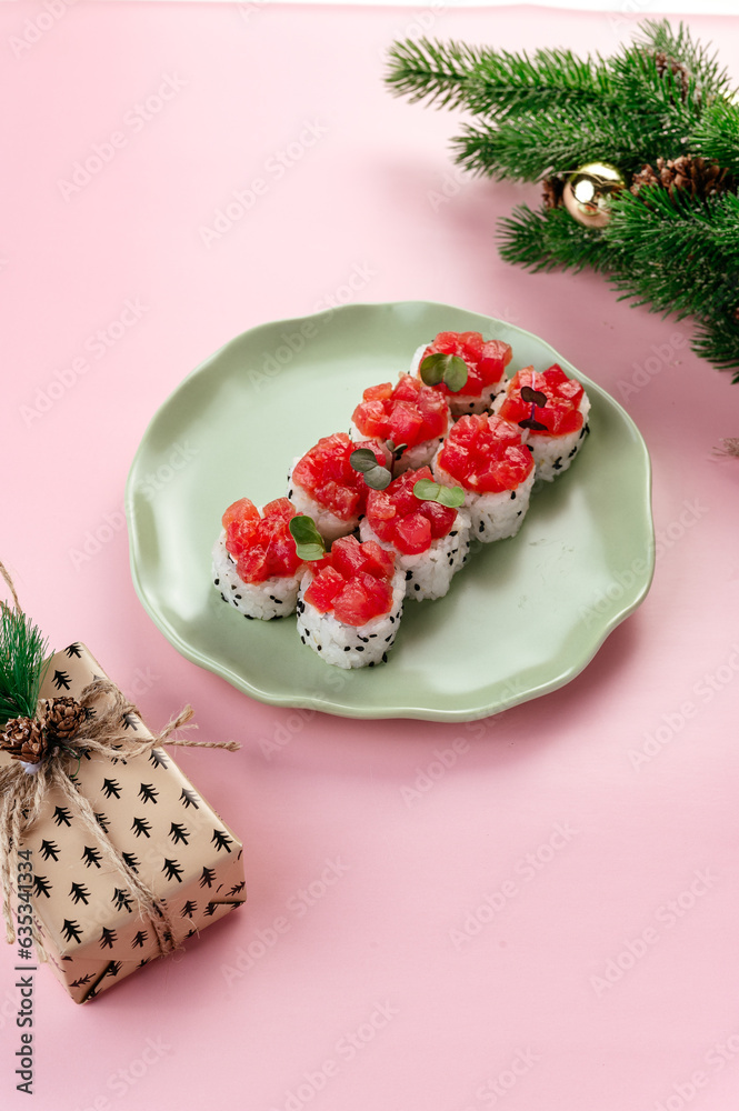 Wall mural japanese sushi rolls with a tuna cap on a plate. new year's deco