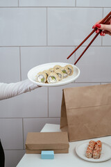 a girl holds a plate of Japanese sushi in her hands