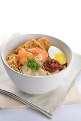 spicy nyonya noodlel malay laksa mee soup with seafood prawn, fish cake, egg, bean curd and chilli sambal thick gravy sauce in bowl on white background asian halal food cuisine menu for cafe design