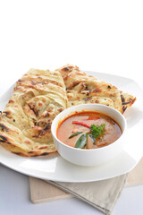 indian baked roti prata canai 2 pieces with spicy chilli curry chicken gravy soup sauce in plate on white background asian halal food cuisine menu for cafe design