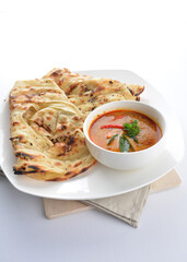 indian baked roti prata canai 2 pieces with spicy chilli curry chicken gravy soup sauce in plate on white background asian halal food cuisine menu for cafe design