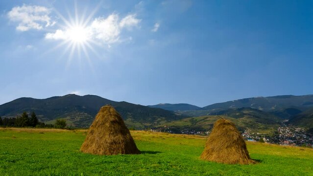  haystack on green pasture in mountain, summer rural time lapse scene