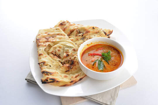 indian baked roti prata canai 2 pieces with spicy chilli curry chicken gravy soup sauce in plate on white background asian halal food cuisine menu for cafe design