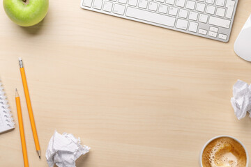 Top view of blank notepad, keyboard, coffee, apple and crumpled papers