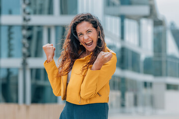 middle-aged woman in the street with euphoric expression of success and joy