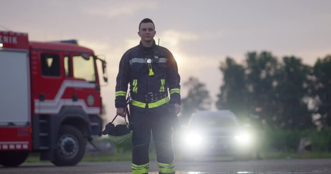 Close-up portrait of a heroic fireman in a protective suit. Firefighter in fire fighting operation.