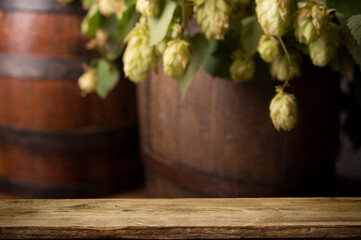 mug of beer, wheat ears, green hops and beer barrel on a wooden background. High quality photo