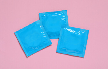 Condom packages on pink background, flat lay. Safe sex