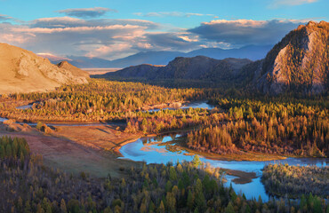A river flows meandering along a picturesque valley, chuya River in the Altai Mountains, evening light