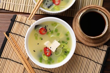 Bowls of delicious miso soup with tofu served on table, flat lay