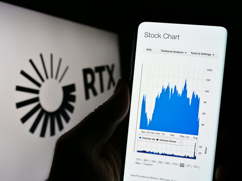 Stuttgart, Germany - 08-06-2023: Person holding cellphone with website of US aerospace and defense company RTX Corporation on screen with logo. Focus on center of phone display.