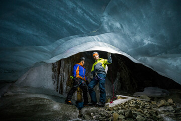 Portrait of two explorers wearing climbing gear in ice cave