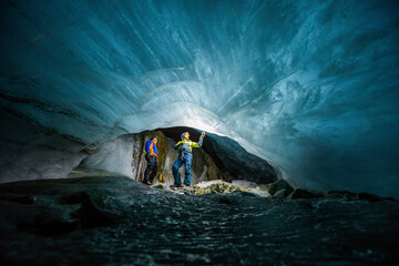 two men marvel at frozen river of ice below a melting glacier