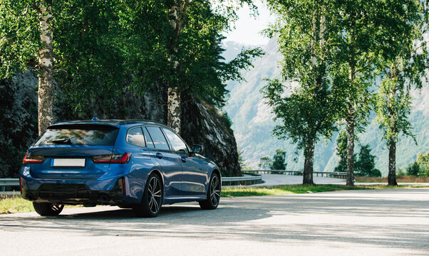family car parked on the side of a beautiful road in Norway