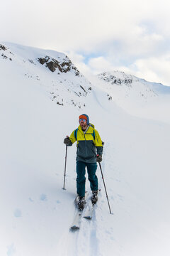Ski tourer on the move, skinning up a mountain during ski trip