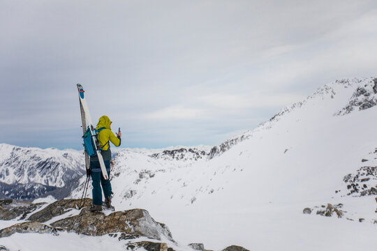 Skier takes photo from mountain summit