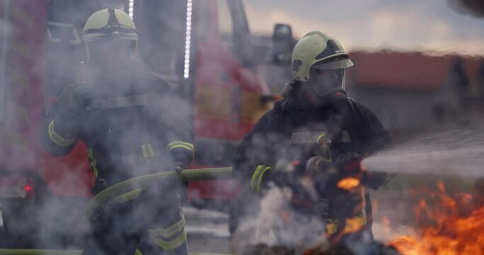Firefighters fight the fire flame to control fire not to spreading out. Firefighter industrial and public safety concept. Traffic or car accident rescue and help action. 