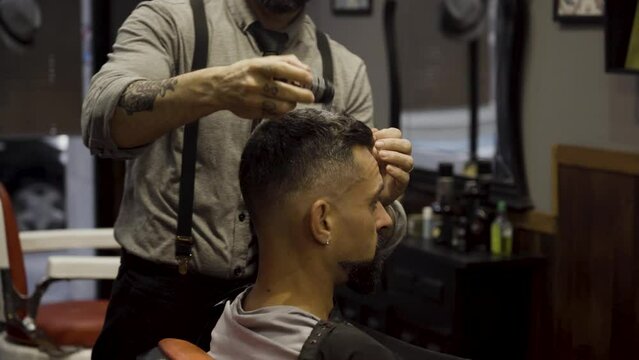 Barber Putting Talcum Powder On The Hair Of A Man In The Barber Shop - close up