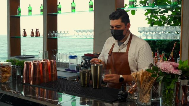 Latin bartender preparing milkshake coffee drink with ice cream at beach bar restaurant mexico with flair routine show