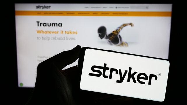 Stuttgart, Germany - 08-09-2023: Person holding smartphone with logo of US medical technology company Stryker Corporation on screen in front of website. Focus on phone display.