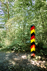 Border post to Germany in the colors black, red and gold on a forest path