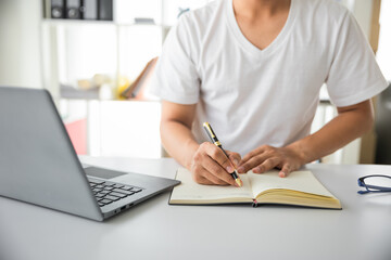 Fototapeta na wymiar Close up of asian man working using laptop computer at home
