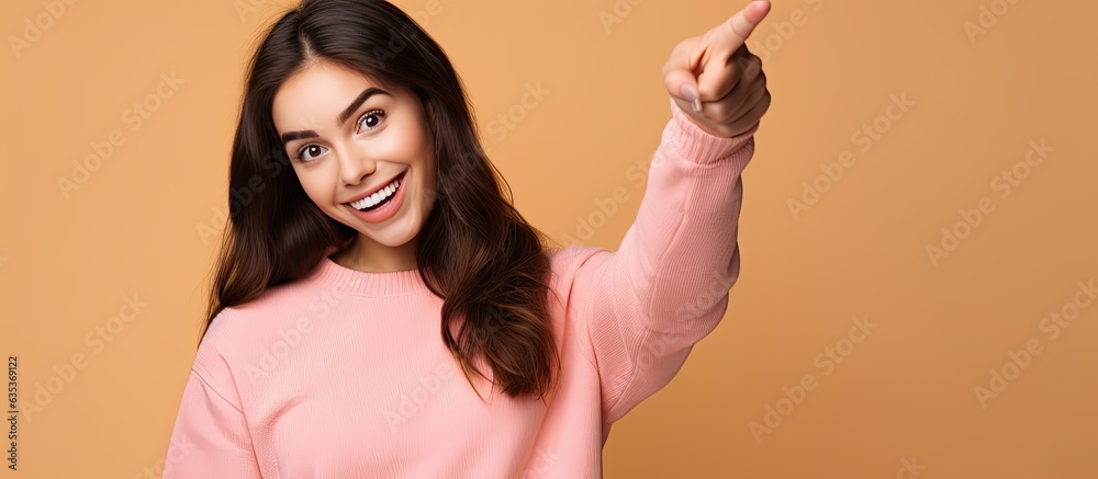Poster happy teenage girl pointing and smiling drawing attention to an object in empty area