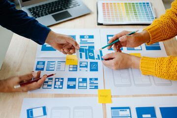  UX developer and ui designer brainstorming about mobile app interface wireframe design with...