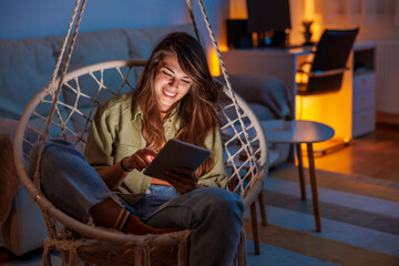 Woman relaxing at home surfing the net using tablet computer