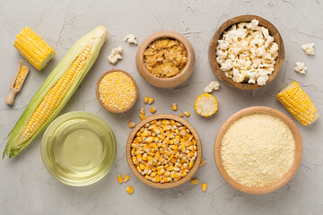 Maize products with fresh corn cobs on concrete background, top view