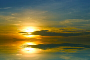 Fototapeta na wymiar reflection sunset colorful dark blue orange sky and dark yellow cloud and sun lower left flame
